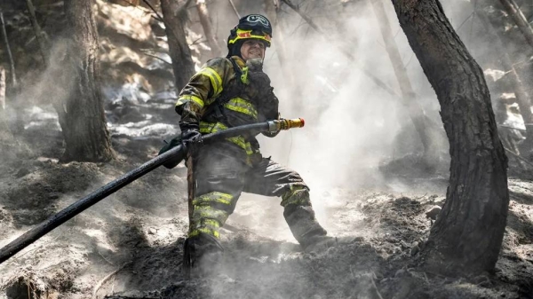 A firefighter sprays water during a wildfire on El Cable Hill near Bogota, Colombia, on 27 January