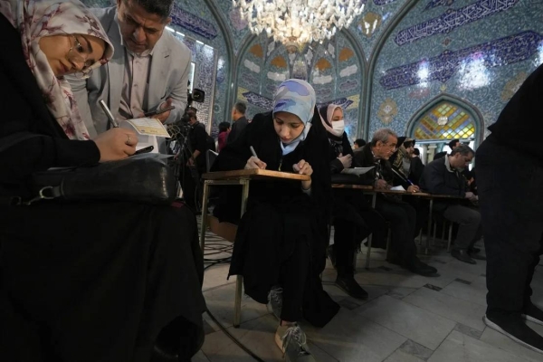Voters fill out their ballots in the parliamentary and Assembly of Experts elections at a polling station in Tehran, Iran, on Friday