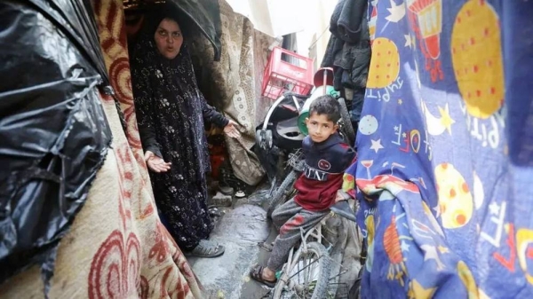 A woman and child stand among makeshift tents at Jabalia refugee camp in northern Gaza. — courtesy Getty Images