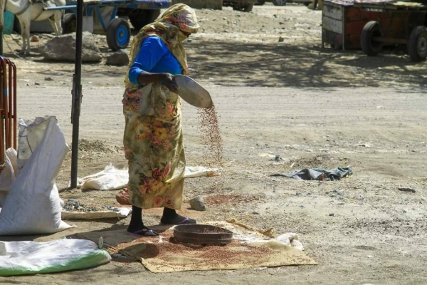 A woman sorts grains at a market in Gedaref, eastern Sudan, on February 22, 2024