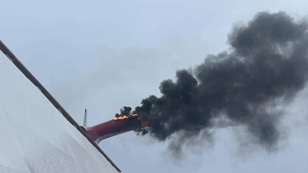 Heath Barnes took this photo of fire and smoke pouring out of an exhaust funnel of the Carnival Freedom cruise ship near the Bahamas, on March 23