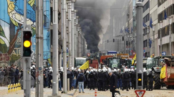 Police move in to clear a demonstration of farmers near the European Council building in Brussels, Tuesday