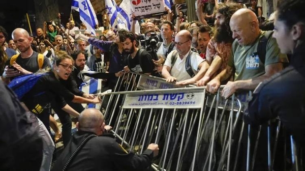 Police try to push back people in a protest against Israeli Prime Minister Benjamin Netanyahu's government