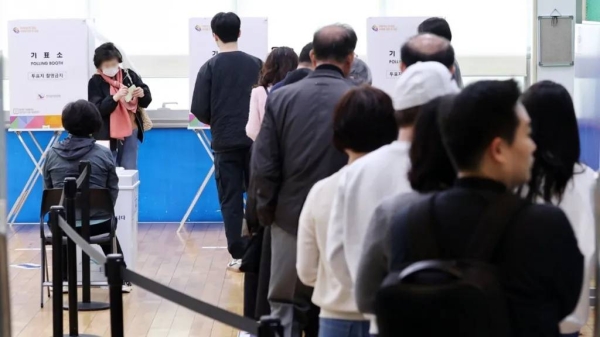 Voters queue to cast their ballot at a polling station in southern Seoul