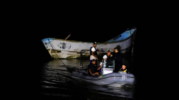 Police officers and rescue workers tow a boat with decomposed bodies found by fishermen, near the Vila do Castelo port in Braganca, Para state, Brazil, on April 14