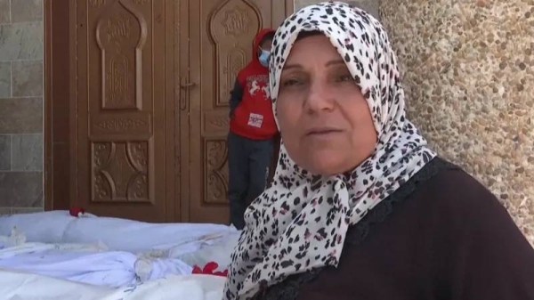 Kareema Elras stands next to bodies exhumed from Nasser hospital, in Khan Younis, southern Gaza. — courtesy BBC