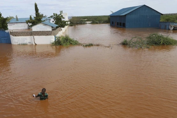A man swims from a submerged church compound, after the River Tana broke its banks following heavy rains at Mororo, border of Tana River and Garissa counties, North Eastern Kenya, on April 28