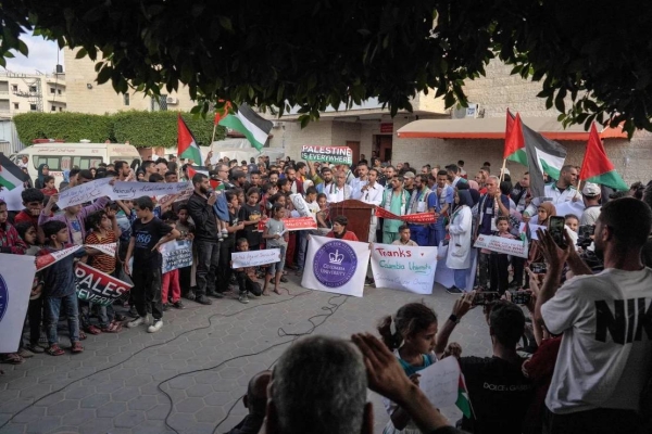 Members of a hospital's medical staff in Deir al-Balah join a rally to thank pro-Palestinian students in the US on May 1, 2024