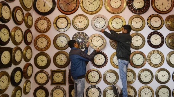 Indian exhibitors hang wall clocks for sale during the 'Punjab International Trade Expo (PITEX) in Amritsar on December 6, 2018