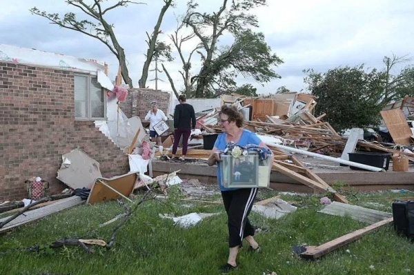 Volunteers clean up after a tornado touched down in Nevada, Iowa