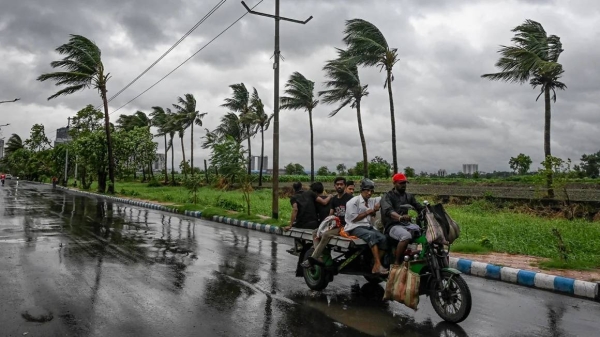 Commuters travel as rain clouds loom over the sky, due to the effect of Tropical Cyclone Remal, in Kolkata, India on May 26, 2024