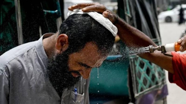 In Karachi, a man has his face sprayed on to cool off during a heat wave