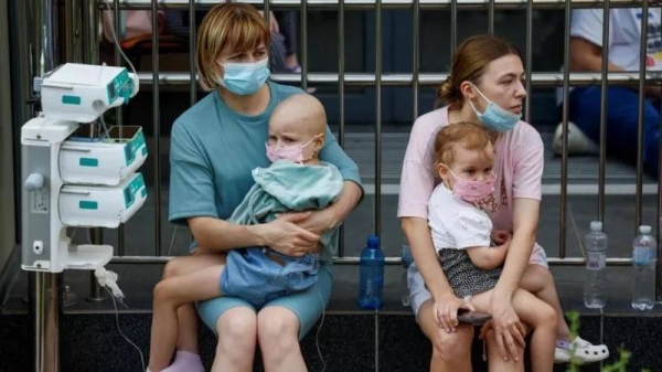 Children with IV drips sat outside the hospital