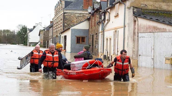 Rescue workers pull residents on a small boat after storm Herminia has unleashed downpours on Ille-et-Vilaine