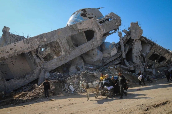 A family rides in a horse-drawn cart past a destroyed mosque in Beit Lahia, Gaza, on January 29