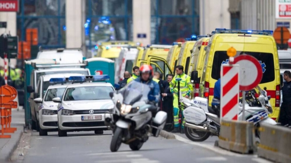 A police motorcycle rides by ambulances at a staging station near a metro after an explosion in Brussels on Tuesday, March 22, 2016