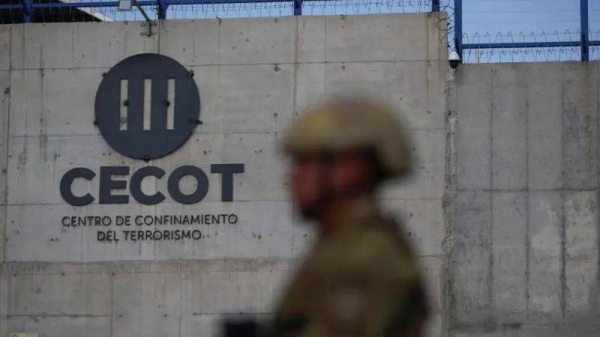 A Salvadoran soldier stands guard, as the CECOT logo is seen, during a media tour at the Terrorism Confinement Center (CECOT) prison, in Tecoluca, El Salvador