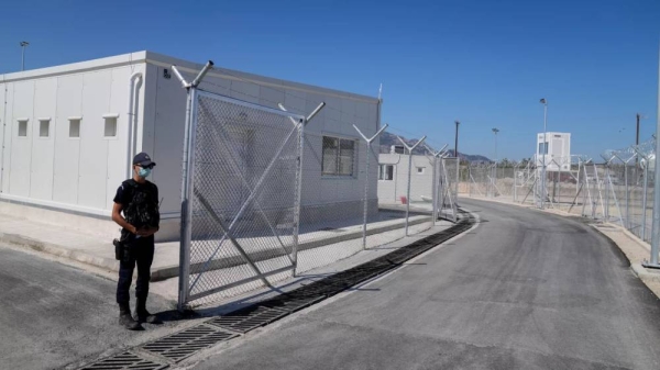 A police officer stands guard at the new closed monitored facility for migrants and refugees in Samos. (Files)