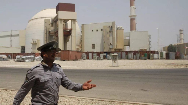 An Iranian security official directs media at the Bushehr nuclear power plant outside the southern city of Bushehr, 21 August, 2010