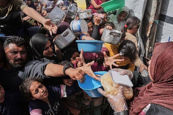 Palestinians wait to get donated food at a distribution centre in Beit Lahiya in the northern Gaza Strip, Monday, 7 April, 2025