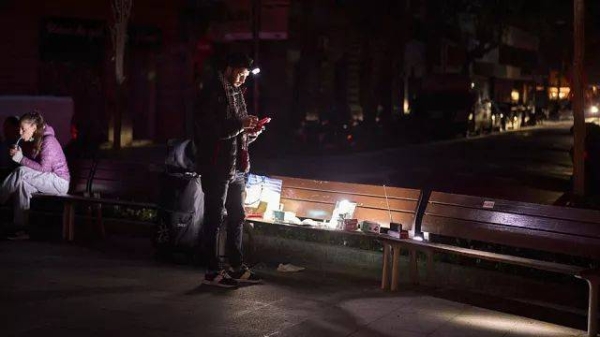 A man sells battery-powered radios and torches on a Barcelona street during the blackout in Barcelona, Spain, Tuesday, April 29, 2025