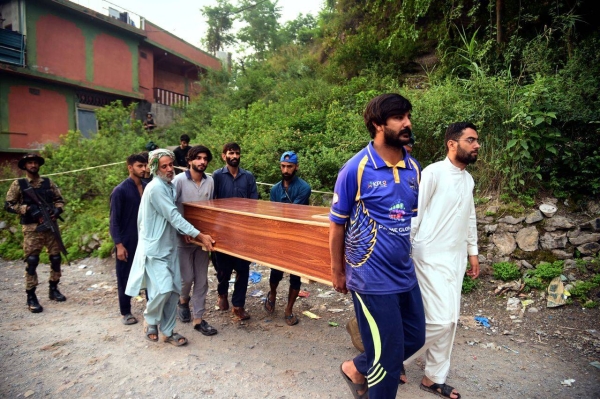 Volunteers carry a body after recovering it from the rubble of a mosque near Muzaffarabad, Pakistan-administered Kashmir