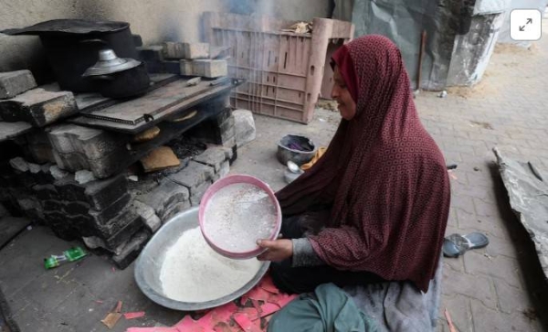 A Palestinian woman prepares bread from spoiled flour, in Gaza City, May 1, 2025.