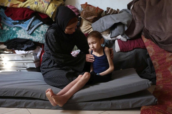 Shuruq Ayyad consoles her 12-year-old daughter Rahaf, who is suffering from malnutrition, at a school-turned-shelter in al-Rimal in central Gaza City on May 4