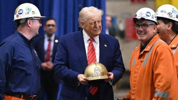 US President Donald Trump receives a gold helmet with his name on it during a visit to US Steel - Irvin Works in West Mifflin, Pennsylvania, May 30, 2025, to mark the deal between Nippon Steel and US Steel