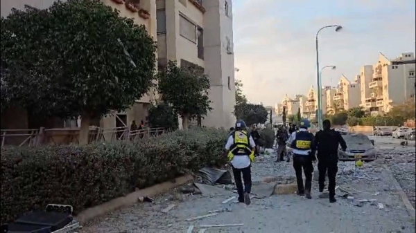 Rescue officials at site of strike on residential building in Beer Sheva, Israel.