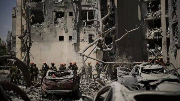 Israeli soldiers from the Home Front Command unit work at the site struck by an Iranian missile strike that killed several people, in Beersheba, Israel, on Tuesday, June 24