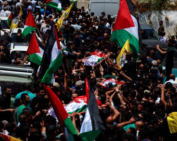 Three Palestinians have been shot dead after nearly 100 Israeli settlers attacked the village of Kafr Malik in the West Bank on Wednesday.