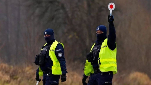Polish police officers patrol cars near the Polish-Belarusian border, that was closed due to a large group of migrants camping in the area on the Belarus side, Poland, 2021