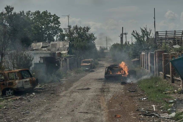 Burnt cars lie in the street as civilians are evacuated from Pokrovsk, Ukraine, by police on June 19