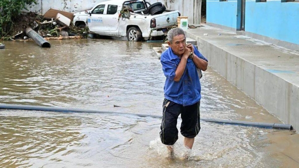A man salvages items as floods hit an area in Miyun district, northern Beijing on July 29, 2025
