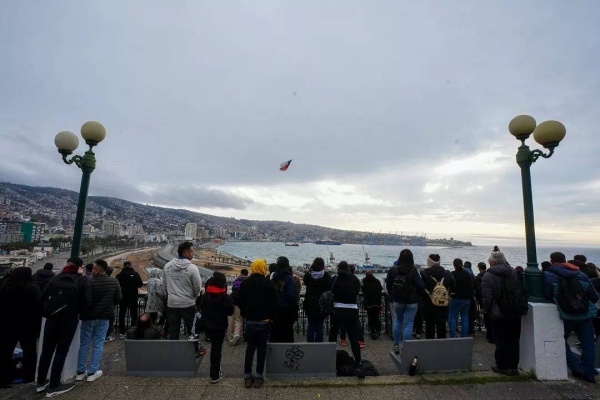 People stand at Baron viewpoint as a loud speaker announces the need to evacuate the area as a precaution in case of a tsunami in Valparaiso, 30 July, 2025