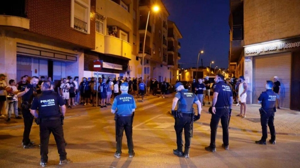 Local police officers and Spanish civil guard agents take positions during the disturbances in Torre Pacheco, eastern Spain, Friday, July 12, 2025
