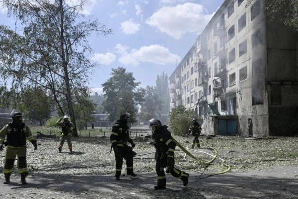 Ukrainian firefighters respond to a blaze after a Russian drone strike in the town of Bilozerske in Donetsk on Sunday