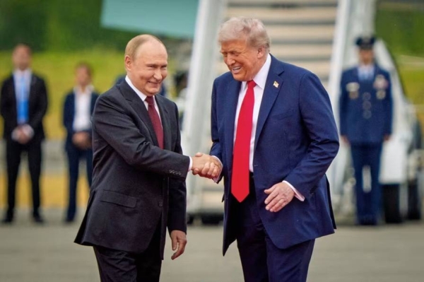US President Donald Trump greets Russian President Vladimir Putin as he arrives for their summit in Alaska on Friday. 