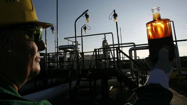 A worker examines a sample at the receiving station of the oil pipeline 'Druzhba', or Friendship, in Szazhalombatta, Hungary -