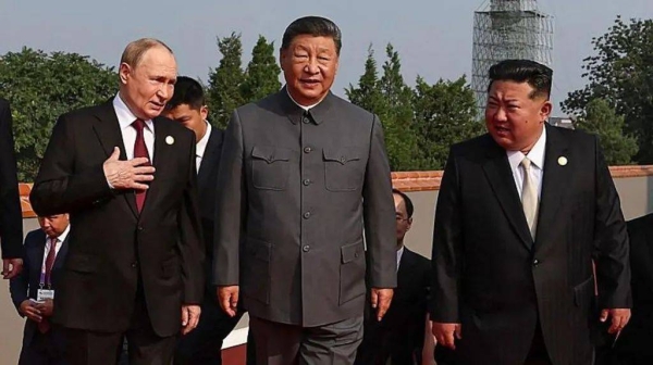 Vladimir Putin, Xi Jinping and Kim Jong Un standing shoulder to shoulder