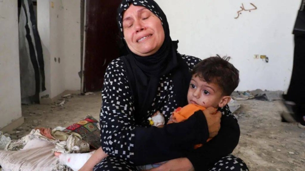 Three-year-old Ibrahim al-Mabhuh is held by his grandmother after an Israeli strike in Gaza City killed his parents and two sisters