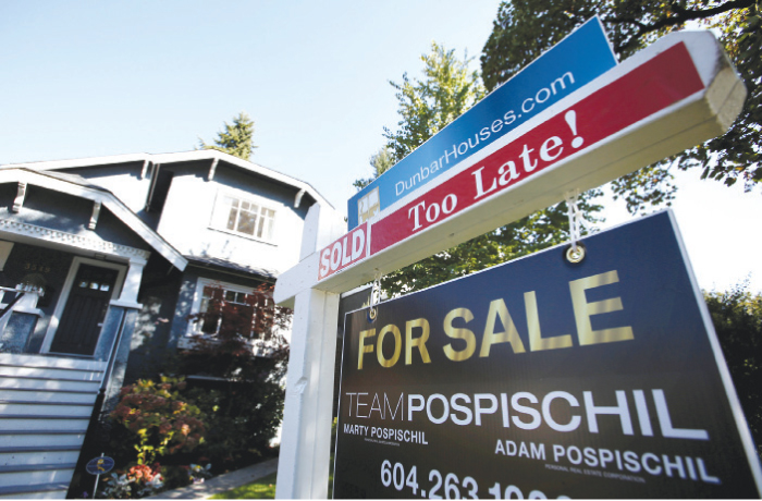 A real estate for sale sign is pictured in front of a home in Vancouver, Canada, on Sept. 22, 2016. —Reuters