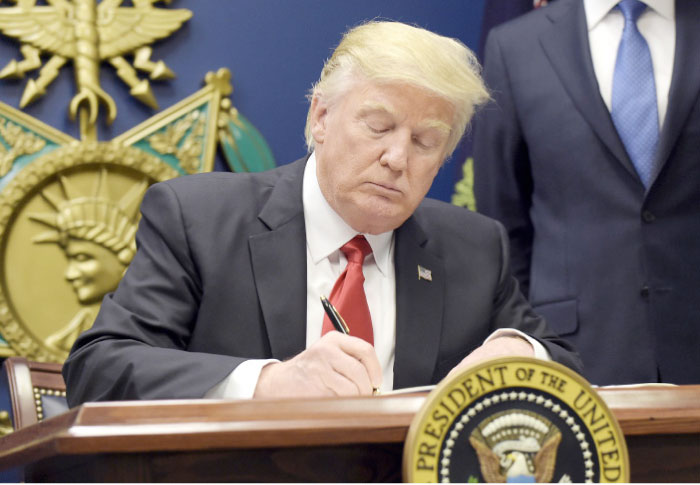President Donald Trump signs an executive order on extreme vetting during an event at the Pentagon in Washington, Friday. — AP