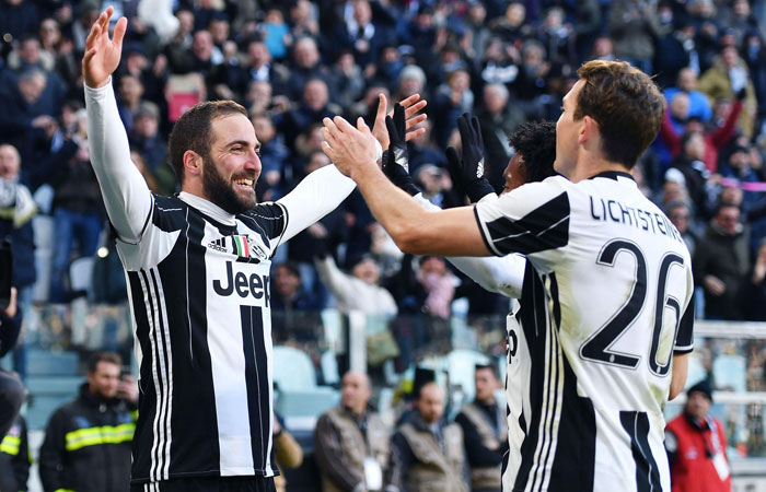 Juventus' Gonzalo Higuain, left, celebrates with his teammate Stephan Lichtsteiner after scoring during a Serie A soccer match between Juventus and Lazio, at the Juventus Stadium in Turin, Italy, Sunday. — AP