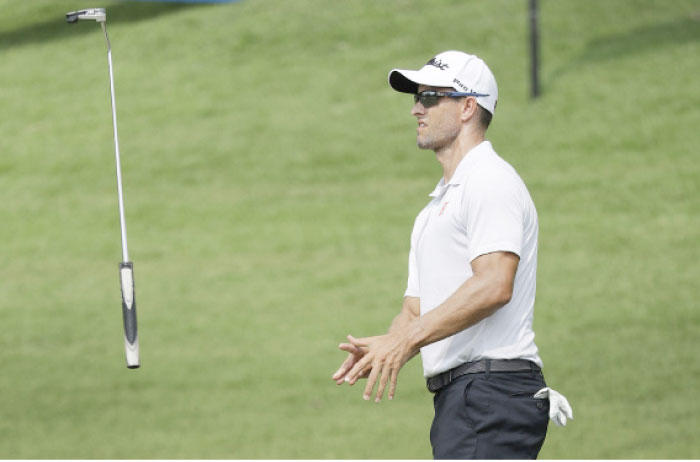 Adam Scott of Australia throws his putter in the air after missing his putt on the 9th hole during the SMBC Singapore Open golf tournament in Singapore Thursday. - AP