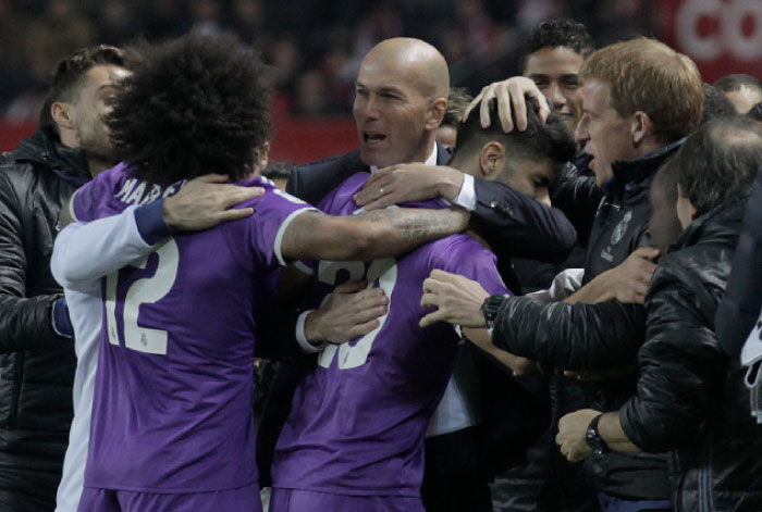 Coach Zidane celebrates with Real Madrid’s players after Marco Asensio scored during their King’s Cup match against Sevilla in Seville Thursday. - AP