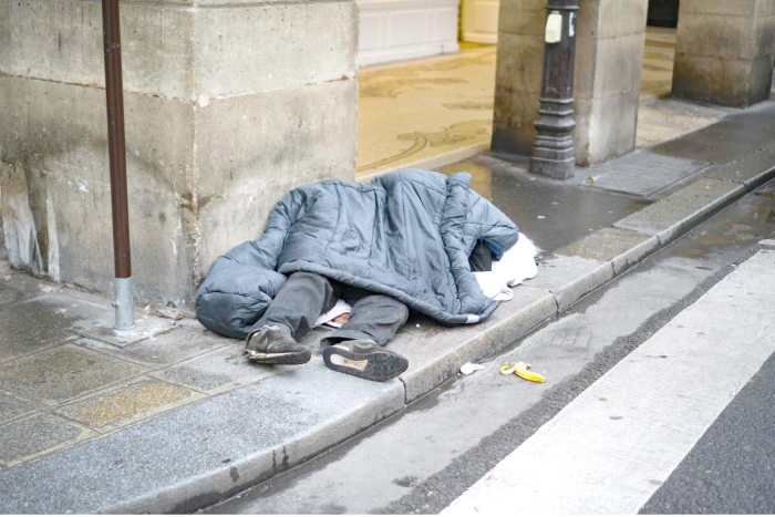 A homeless man sleeps on a street in central Paris on Sunday, as a cold wave hits much of Europe. — AFP