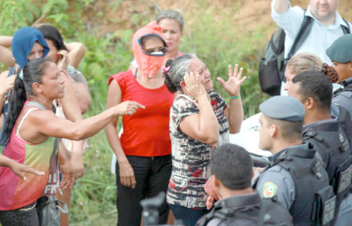 Relatives of prisoners react near riot police at a checkpoint close to the prison where around 60 people were killed in a prison riot in the Amazon jungle city of Manaus, Brazil, on Monday. — Reuters