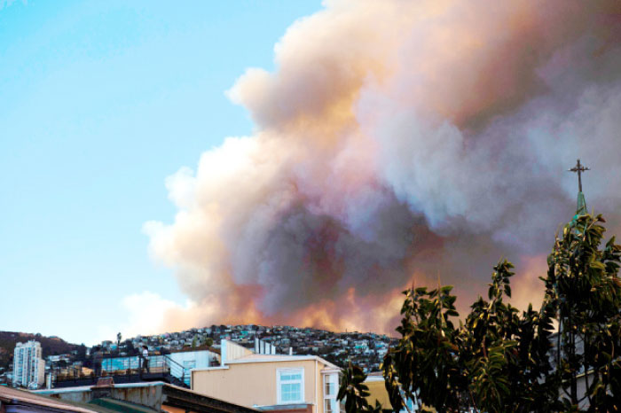 Smoke billows from a forest near Valparaiso, in Chile, on Monday as the fire threatens to reach the city›s port, authorities have declared a red alert in the area. — AFP